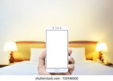 Man hand using smartphone take photo at hotel room blurred background