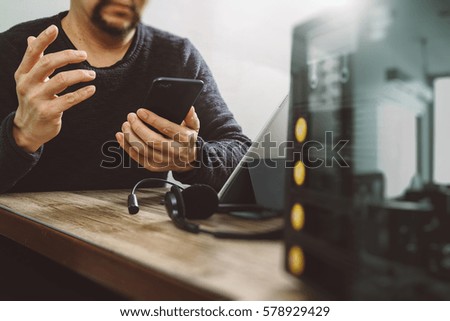 man hand using VOIP headset with smart phone and digital tablet computer  as call center and customer service help desk with compact server at foreground as concept