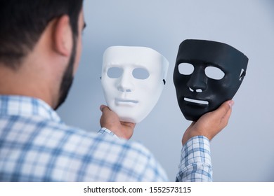 Man Hand White And Black Mask On Gray Background
