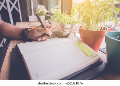 man hand write a short note on opened notebook with pen. Flat layout and copy space.