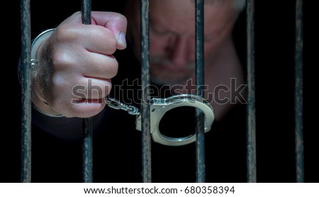 A man is handcuffed to a lattice