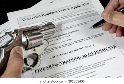 Man With Handgun Firearm Pistol And Concealed Carry Permit Application