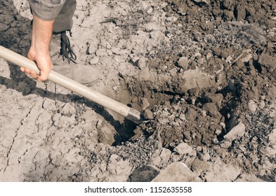 man is handing shovel and digging a pit - Shutterstock ID 1152635558