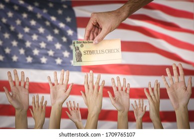 Man Handing Stimulus Check To People With The USA Flag On The Background. The US Government Is Preparing To Send Out Direct Payments To Help Individuals Amid The Coronavirus Pandemic