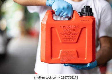 man handle red plastic fuel gallon flammable material container for refill gasoline car tank