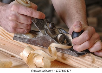 Man hands with carpenters plane on wooden background - Shutterstock ID 1727587477