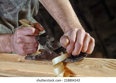 Man hands with carpenters plane on wooden background