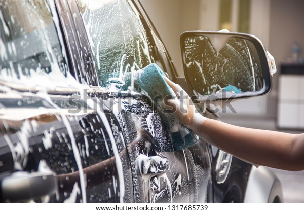 Man hands to catch the sponge and polish the car\
window. Concept car wash.