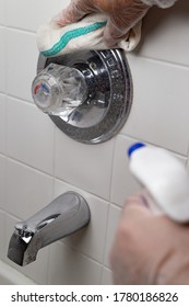 Man Hands Cleaning Bath Tub Faucet Wearing Silicone Gloves And Spraying With Liquid.