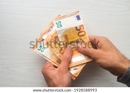 Man hands counting euro cash money banknotes on white table