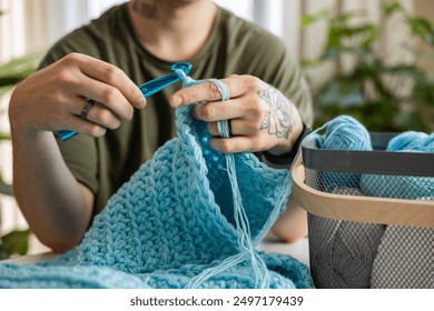 Man hands crochets handmade crocheting supplies assorted colored wool yarn hook knitting top view closeup. Feminine male enjoy handiwork handcrafted hobby create unique warm craft clothes workshop - Powered by Shutterstock