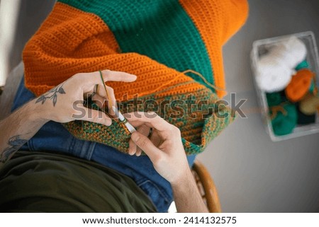 Man hands crochets handmade crocheting supplies assorted colored wool yarn hook knitting top view closeup. Feminine male enjoy handiwork handcrafted hobby create unique warm craft clothes workshop