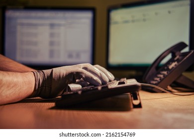 Man Hands In Dark Gloves Typing On A Computer Keyboard Against The Backdrop Of A Night Office