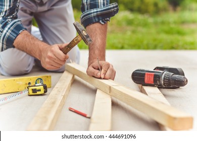 Man Hands Drive Nail With A Hammer In Wooden