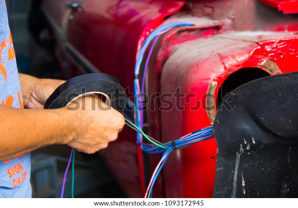 man hands of electrician works in car. Service
working with car wiring
cables.