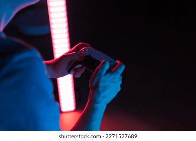 Man hands with game controller in neon light, top view - Powered by Shutterstock