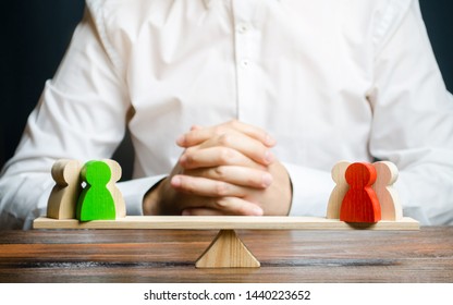 A man with hands in the gesture of a lock and looks at the red and green standoff groups on a scales. conflict resolution and the search for a compromise in the dispute. Research argument of each side