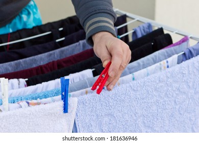 Man Hands Hanging Wet Clothes On Clothes-line For Drying