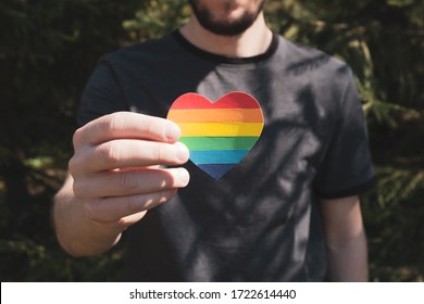 An einem sonnigen Tag halten die Menschen Herz in den Farben des Regenbogens. LGBT Rechte, Pride Monat, Toleranz und Liebeskonzept. Nahaufnahme