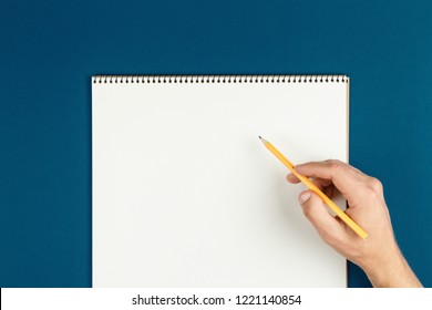 man hands hold opened notebook pages with pencil, schoolboy doing homework, desk of office worker flat lay. empty notepad on table