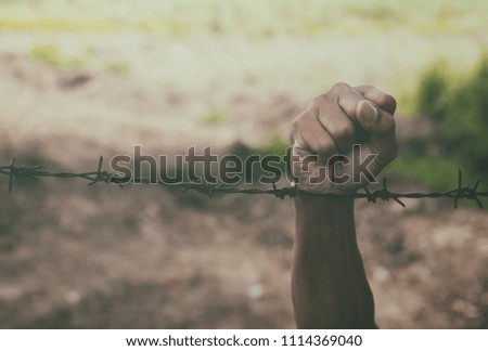 man hands hold the rusty sharp bare wire with hope longing,Human rights concept.