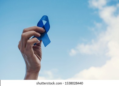Man Hands holding blue ribbon over blue sky, Prostate Cancer Awareness, November blue, Movember Men health awareness, world diabetes day - Shutterstock ID 1538028440