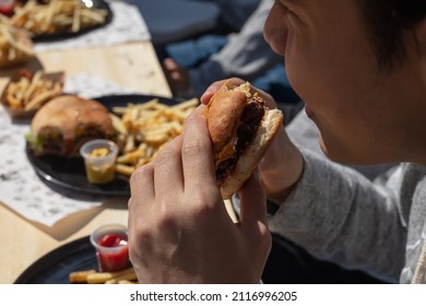 Man Hands Holding Burger Outdoors