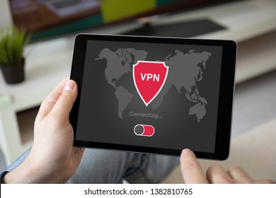 man hands holding computer tablet with app vpn on screen in the home room
