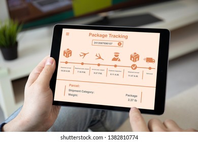 Man Hands Holding Computer Tablet With App Package Tracking On The Screen In The Home Room