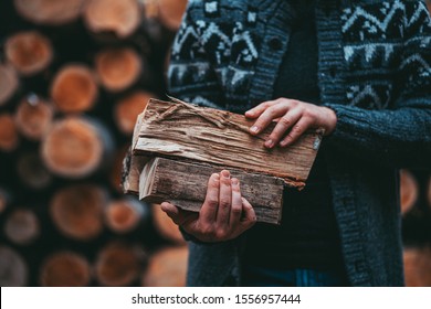 Man Hands Holding Firewood. Unrecognizable male caring wood logs to the house, to start a fireplace. Rustic countryside background, still life. slow living.