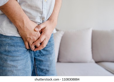 Man with hands holding his crotch, he wants to pee - urinary incontinence concept. Sick man prostate cancer, prostate inflammation, premature ejaculation, fertility, erection or bladder problem
