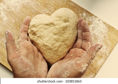 Man hands holding homemade heart shaped pastry on a wooden board - Powered by Shutterstock