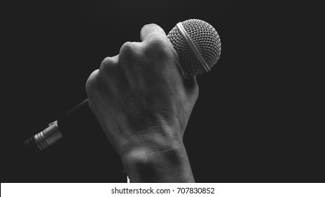 Man Hands Holding Microphone On Stand.