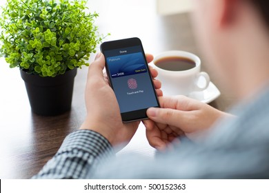 man hands holding phone with debit card touch and pay on screen in cafe