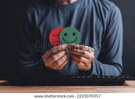 Man Hands holding sad face hiding or behind happy smiley face, bipolar and depression, mental health concept, personality, mood change, therapy healing split concept.	
