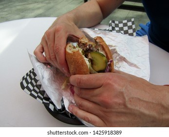 Man Hands Holding Unwrapped Hamburger
