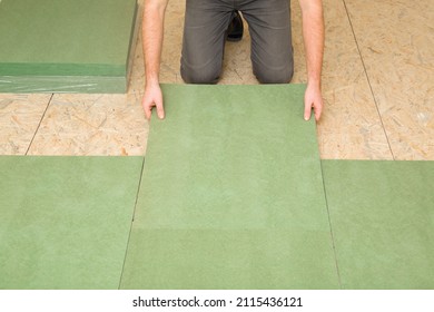 Man hands laying green natural wood fiber insulation board. Preparing surface from fibreboard underlay for laminate or parquet floor. Repair work of home. Renovation process. Closeup. Front view. - Shutterstock ID 2115436121