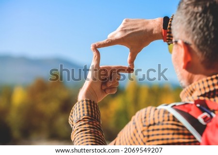Man hands making frame gesture looking at mountain landscape. Hiking among beautiful nature views and making pictures in memory. Hands making frame gesture. Save planet.