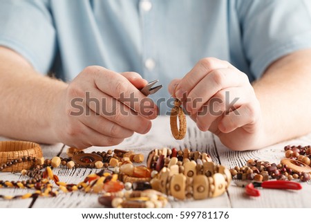 man hands making handcrafted wood earrings, close up