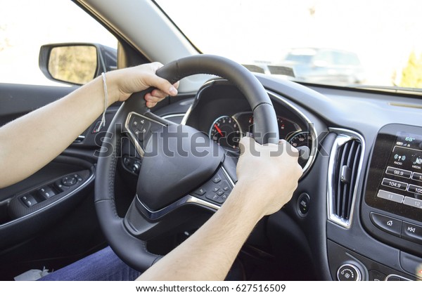 Man with hands on\
driving wheel in car