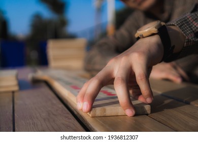 Man Hands Playing Giant Dominoes On A Wooden Table Outdoors