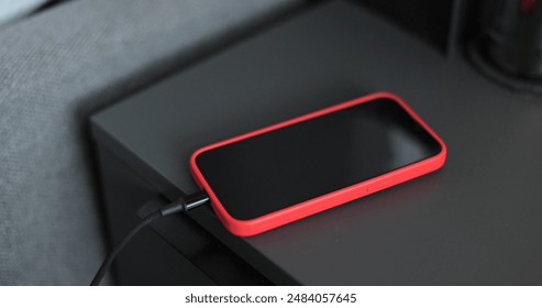 Man hands plugging a charger in a smartphone on bedside table. Mobile smartphones charging. - Powered by Shutterstock