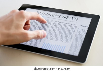 Man hands are pointing on touch screen device with business news. - Powered by Shutterstock