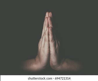 Man hands in praying position low key image