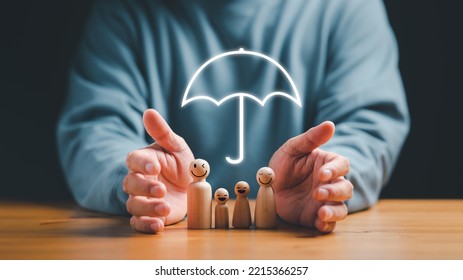 Man Hands Protecting With Umbrella On Family Wooden Model, Insurance And Assurance Life Concept, Life Insurance Coverage.