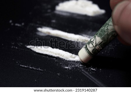 Man hands rolls banknote for using cocaine powder lines. Drug addiction concept. A line of coke on black background. Concept of addiction. Mephedrone, amphetamine, heroin. Serious 
