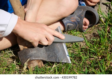 Man Hands Sharpening Ax Blade