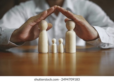 Man hands shield wooden figures, embodying protection and security with a determined gesture, symbolizing strength and guardianship
 - Powered by Shutterstock