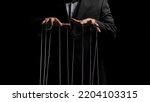 Man hands with strings on fingers on black background. Violence, harassment, bullying concept. Master in business suit, abuser using influence to control person behavior. Manipulation of government.