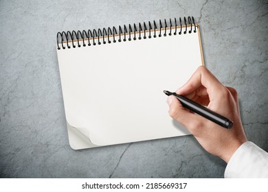 A Man Hands Is Trying To Drawing In A Notebook. Test For Essential Tremor And Parkinson's Disease.